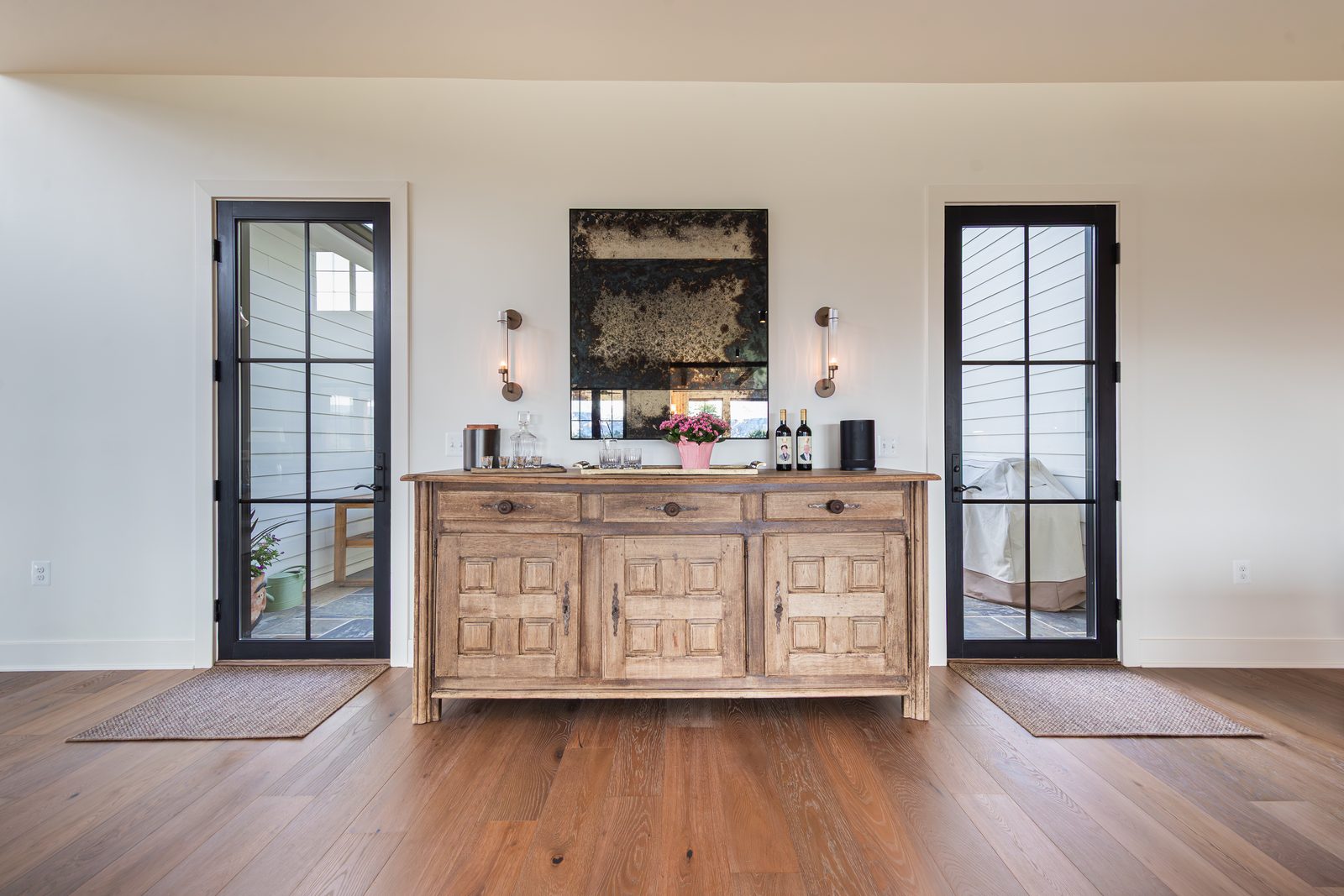 A carved console between two tall windows