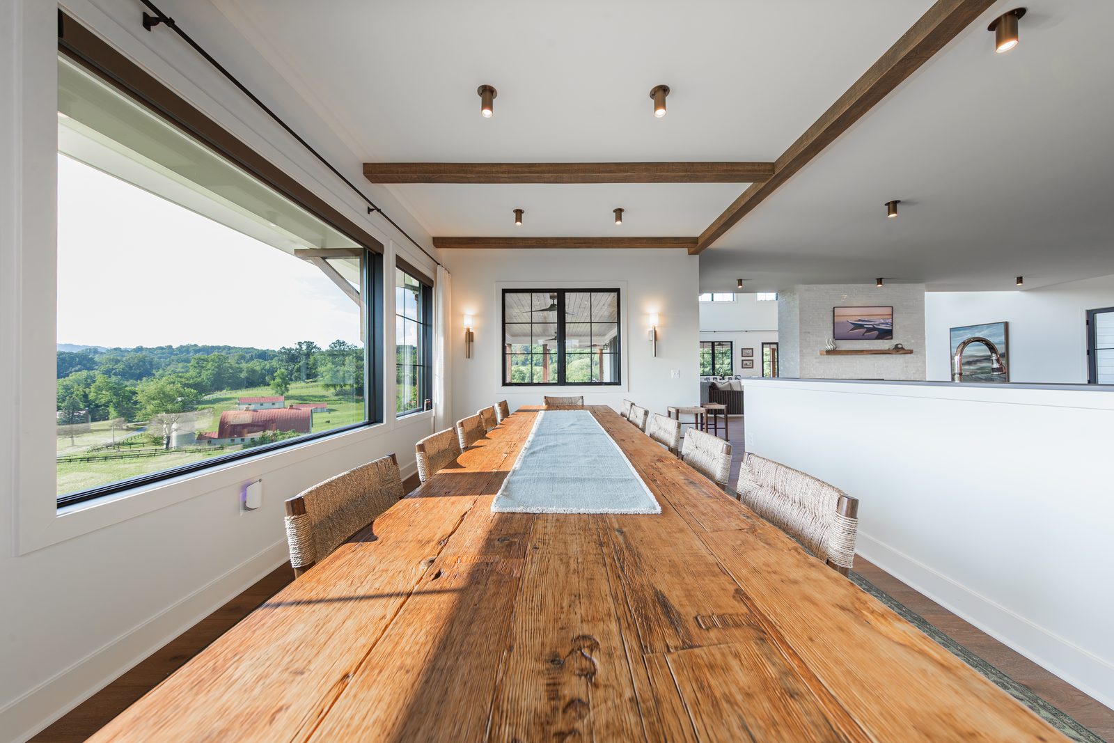 The long dining table beside a wall of windows