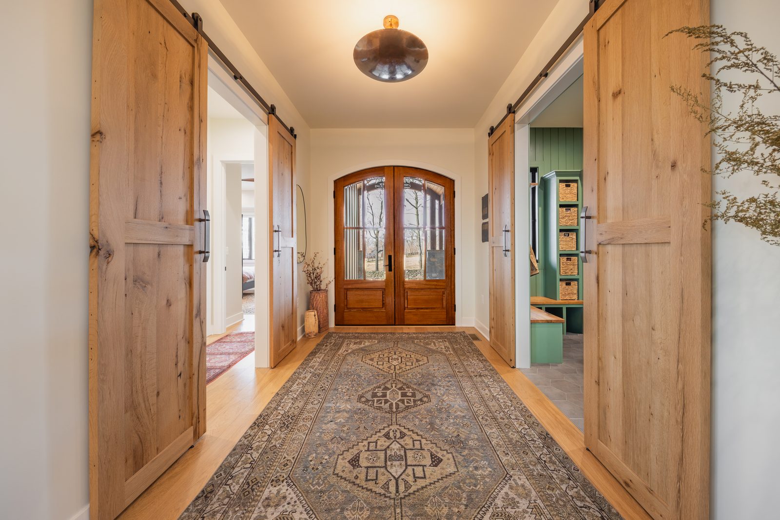 The entry hall between barn doors, leading to the arched front doors