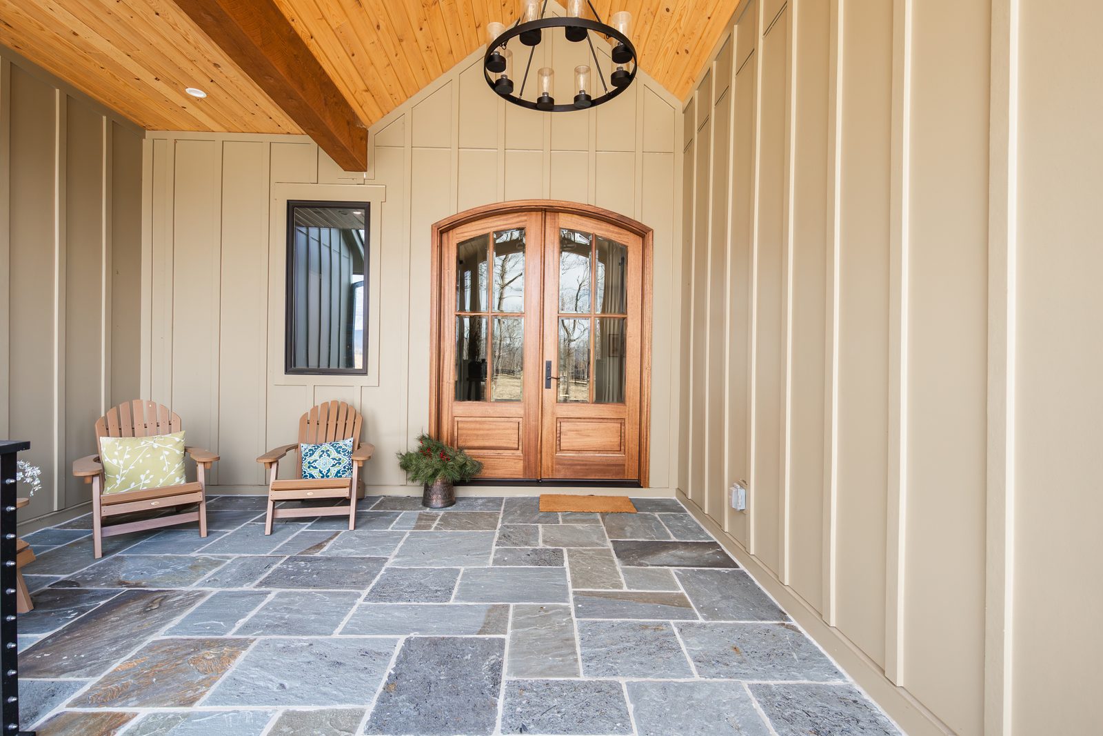 The stone-floored front porch and arched entry doors