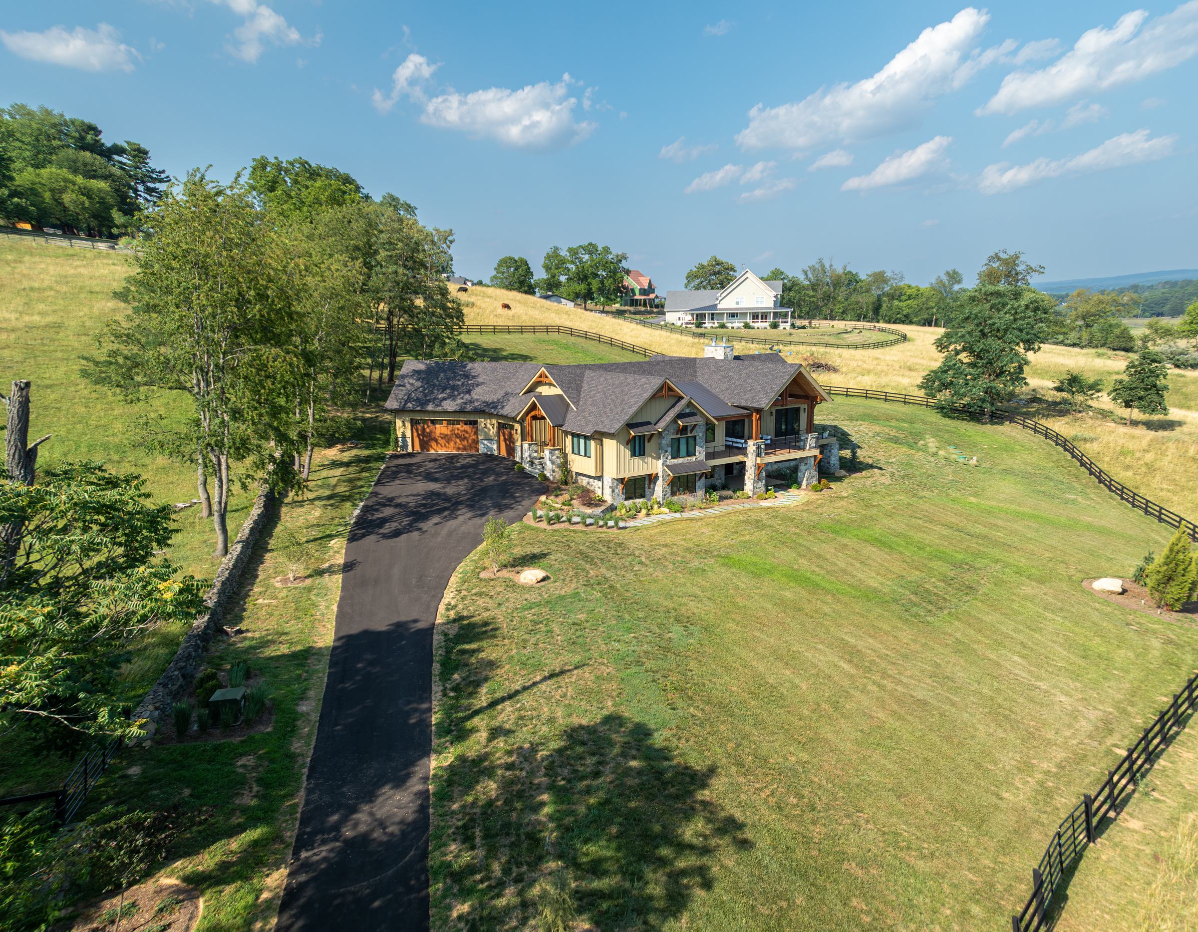 The driveway curving up to Mountain Craftsman through the pasture