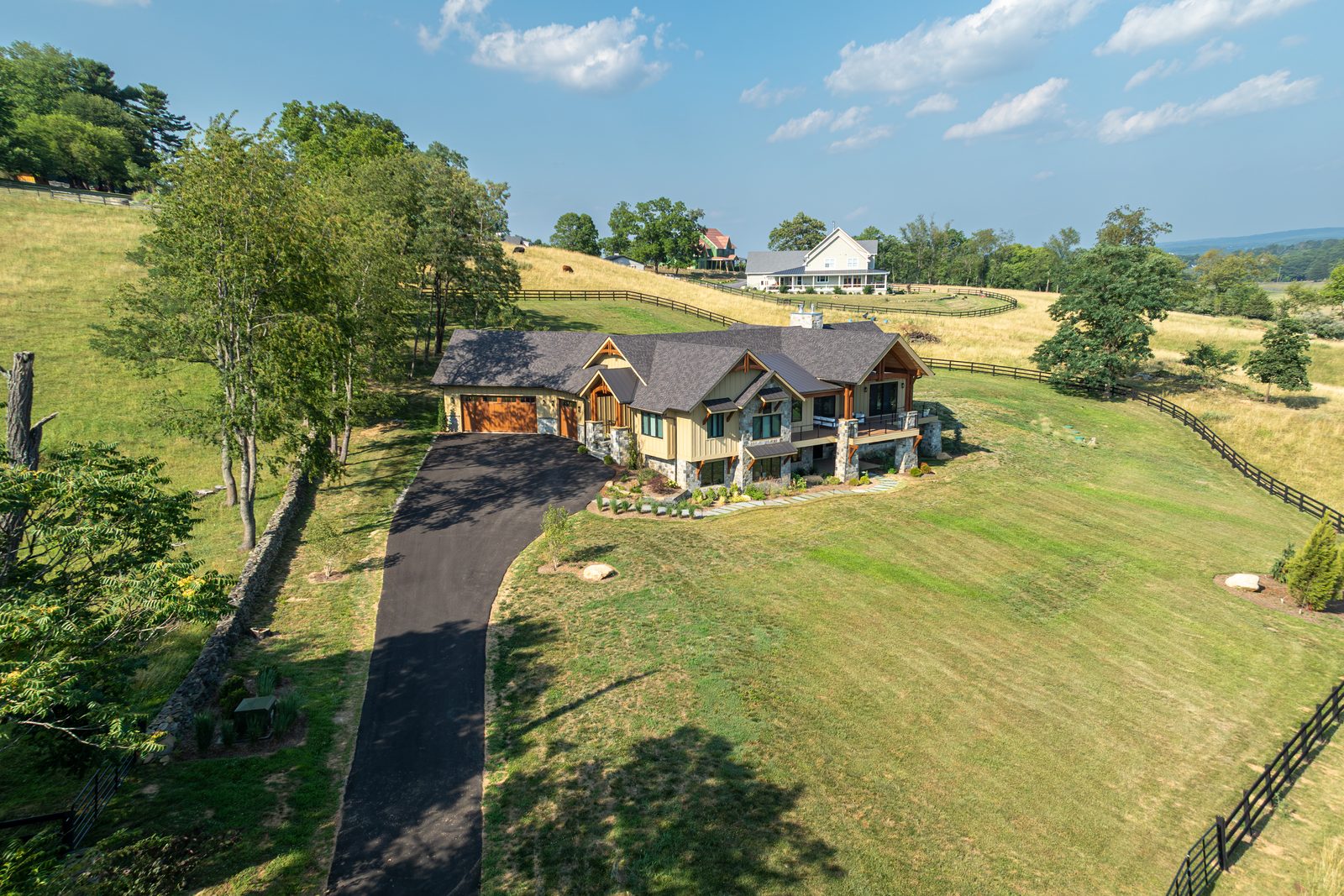 The driveway curving up to Mountain Craftsman through the pasture